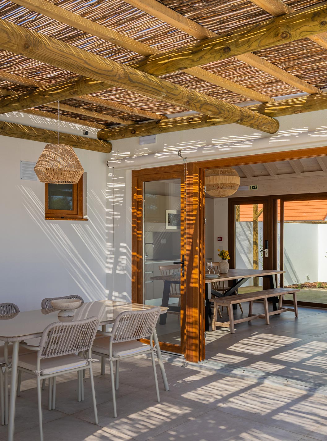 A Premium Villa do Pestana Comporta Village Residences tem um pátio coberto com uma mesa que dá acesso ao interior