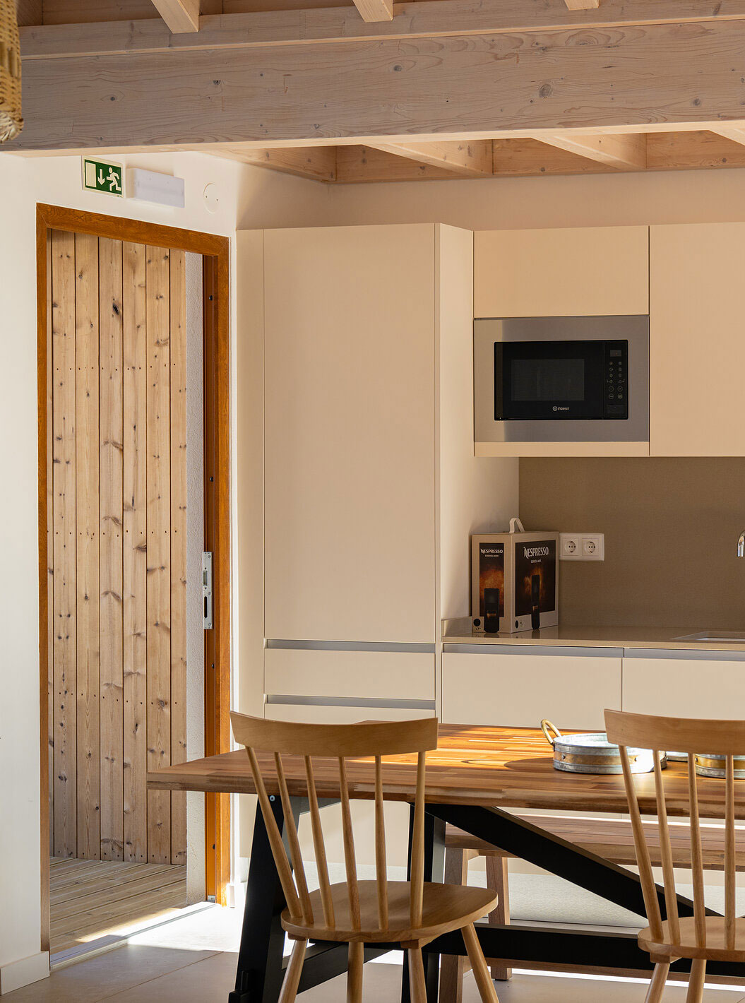 A Superior Villa do Pestana Comporta Village Residences tem uma cozinha moderna com uma mesa de madeira e forno