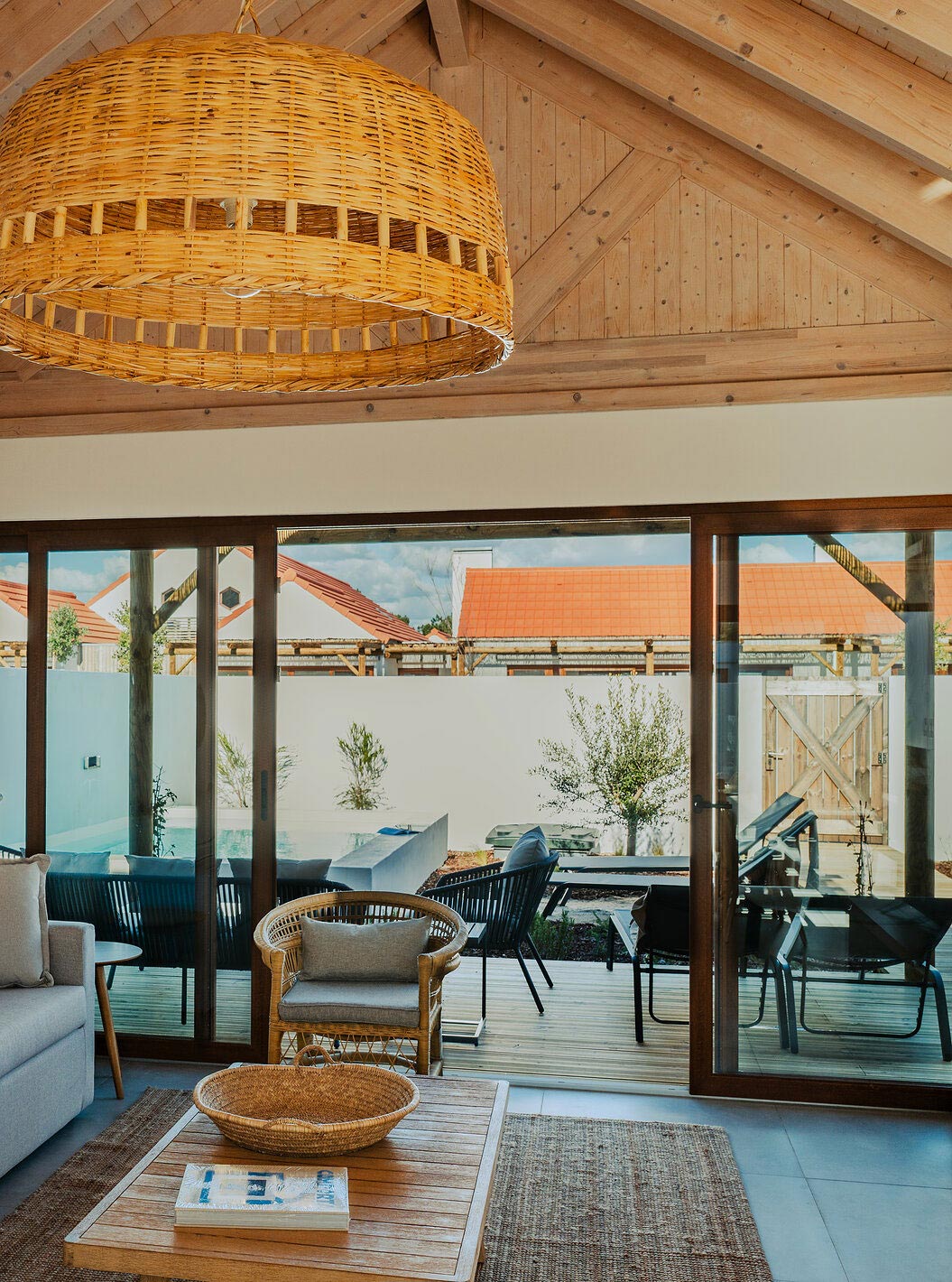 A Superior Villa do Pestana Comporta Village Residences tem uma sala de estar com um sofá cinza e uma varanda ao fundo