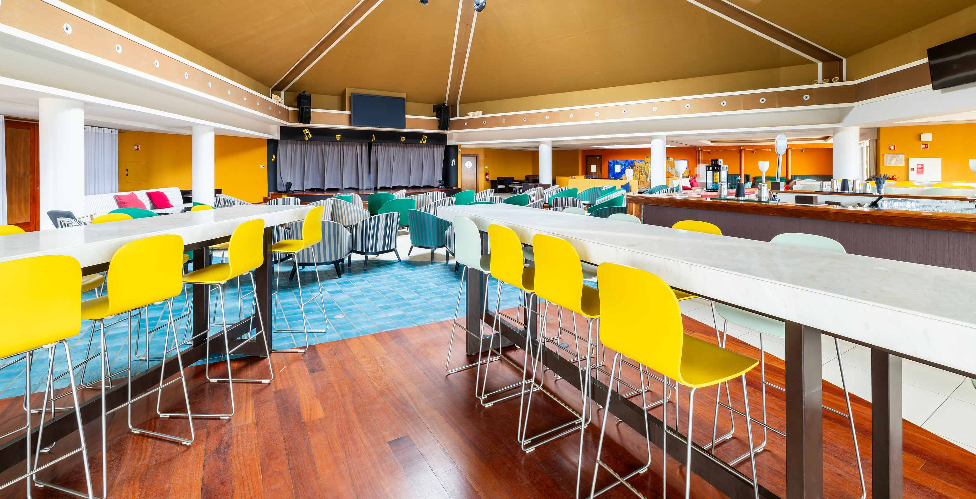 Restaurante do Pestana Porto Santo, Resort de 5 Estrelas no Porto Santo, com mesas coloridas e cadeiras modernas