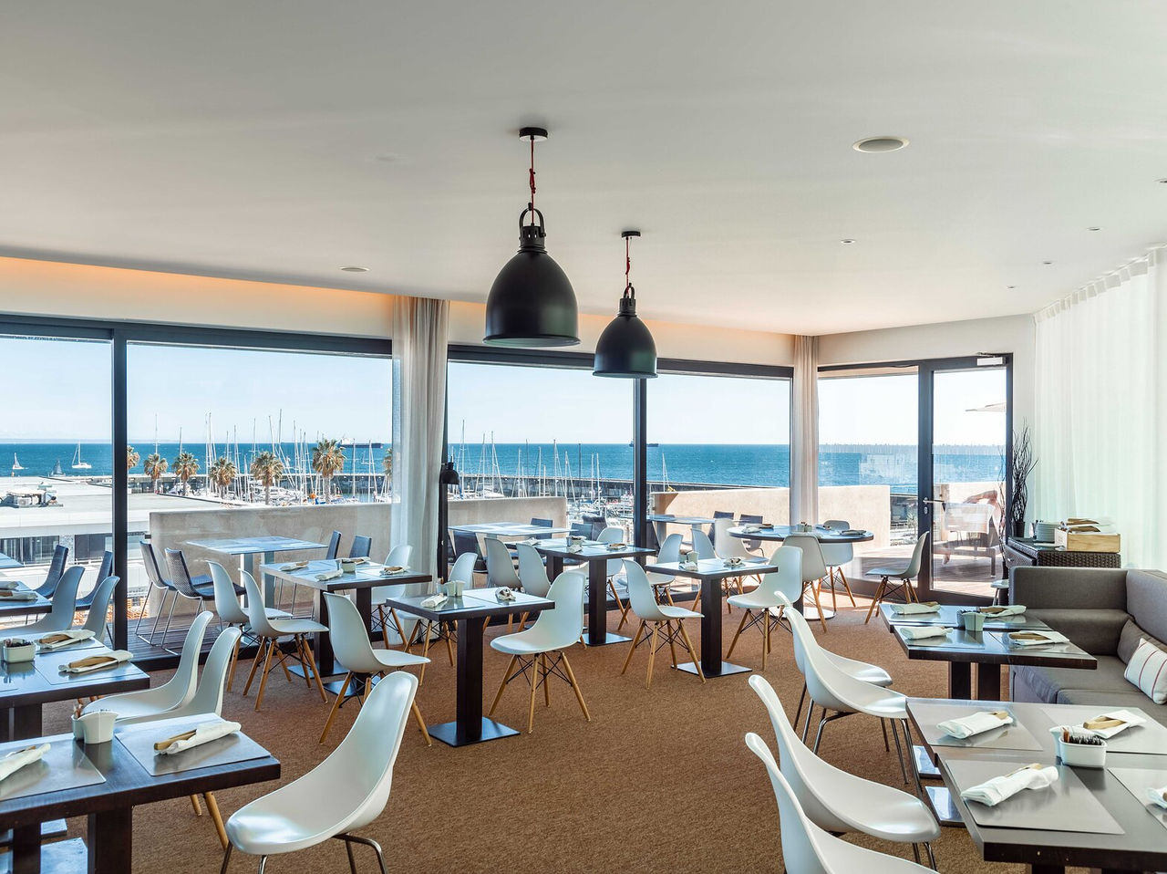 Restaurant Maris Stella in het 5-sterrenhotel in Cascais heeft veel tafels, stoelen en uitzicht op de jachthaven van Cascais