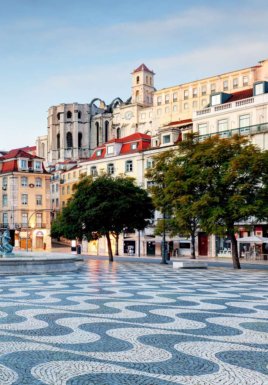 Uitzicht op de Praça do Rossio, met Portugese tegels, een fontein en verschillende gebouwen rondom