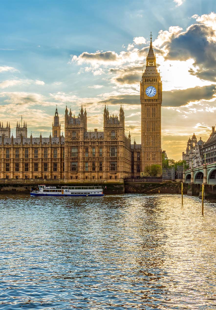 Uitzicht op Big Ben en Buckingham Palace, met zonlicht door de wolken en de rivier en brug op de achtergrond