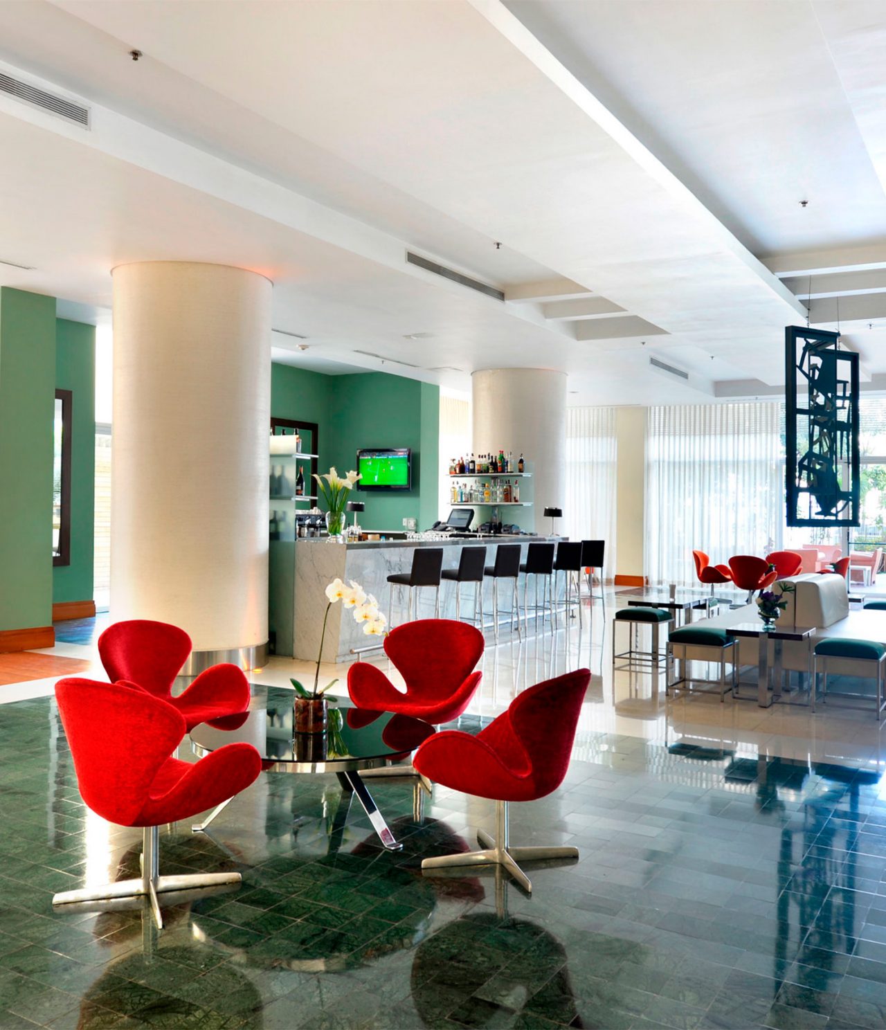 De Lobby Bar, van het Hotel in Caracas, heeft veel natuurlijk licht, een televisie en tafels voor een drankje