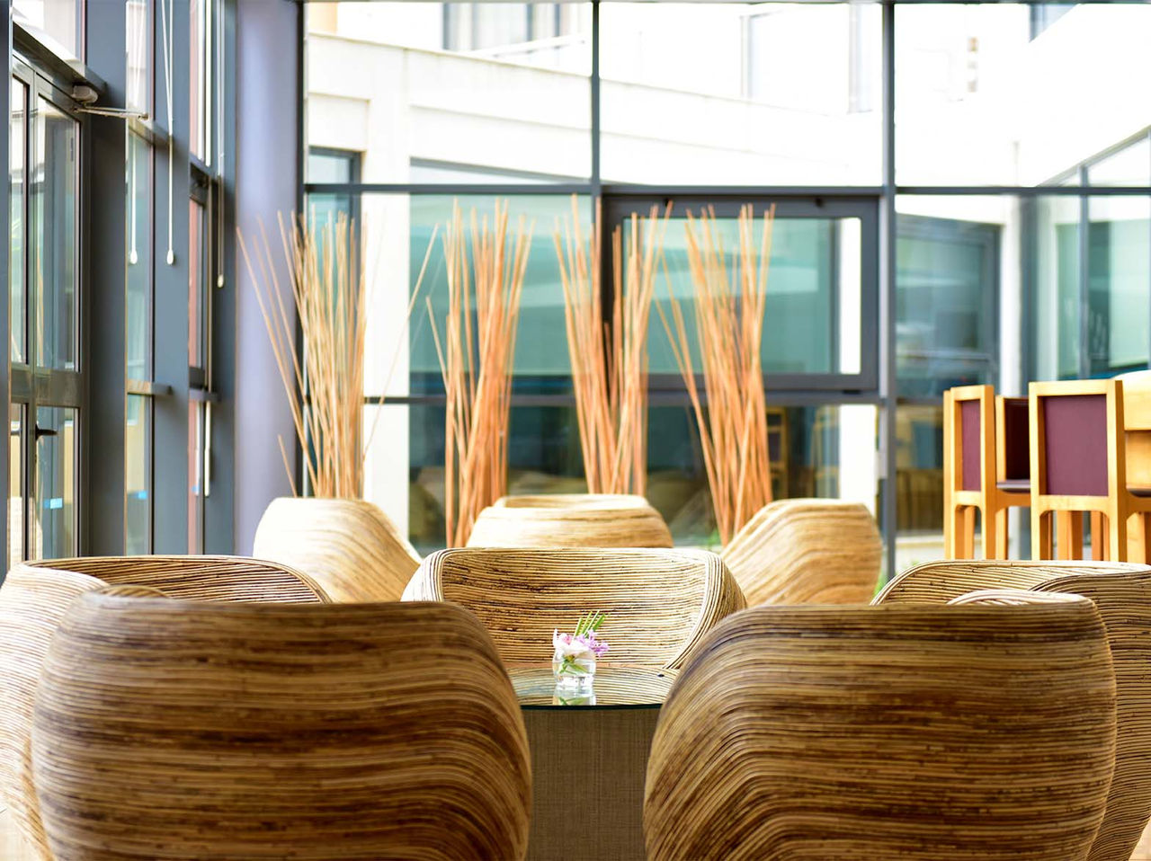 A Adega Bar has round chairs, central tables, bar counter, and glass doors