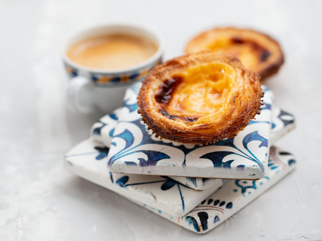 The famous pastel de nata, a typical Portuguese delicacy, accompanied by an espresso or "bica," as it is colloquially known