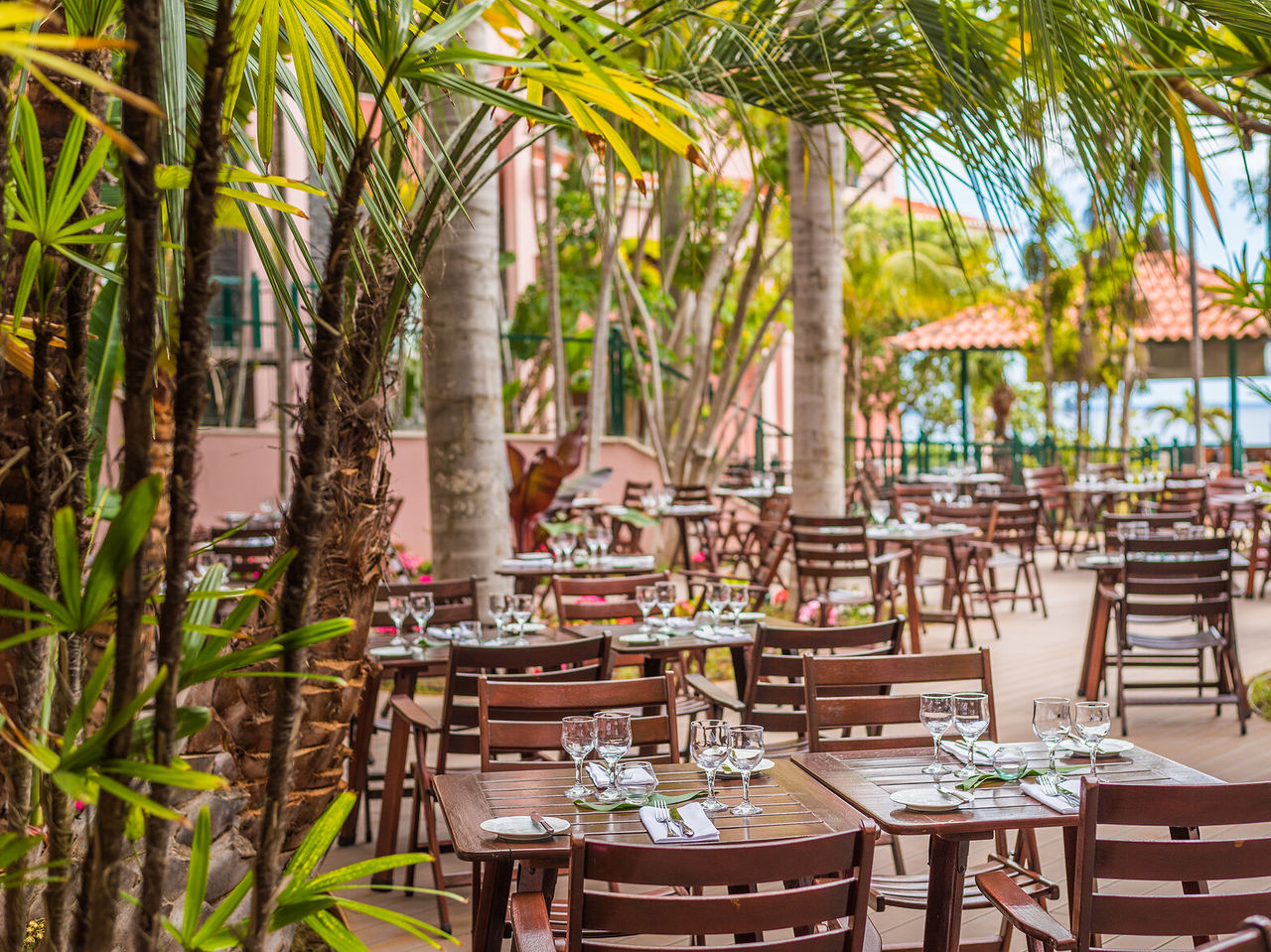The Botanic Terrace restaurant, at the 5-Star Hotel in Funchal, has an outdoor dining area with tables and chairs
