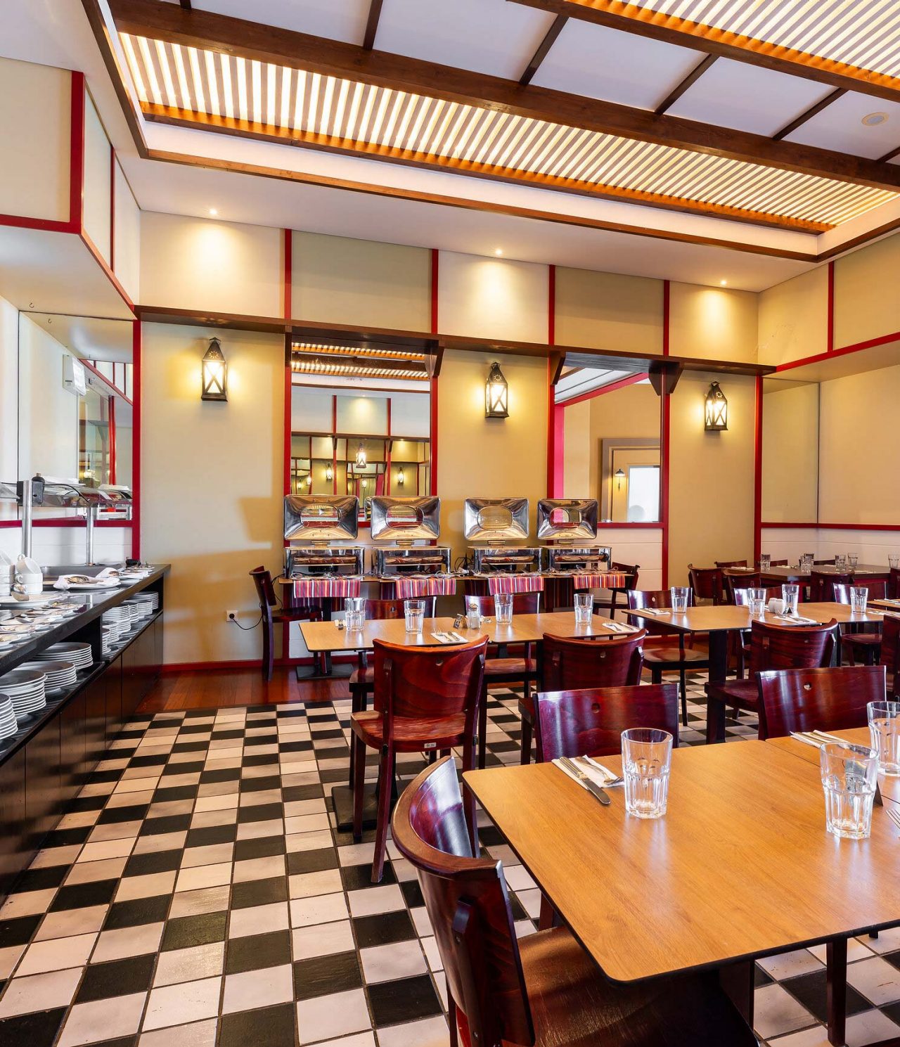 The Luigi restaurant at the 5-star Resort in Porto Santo has a floor with black and white tiles and dark chairs.