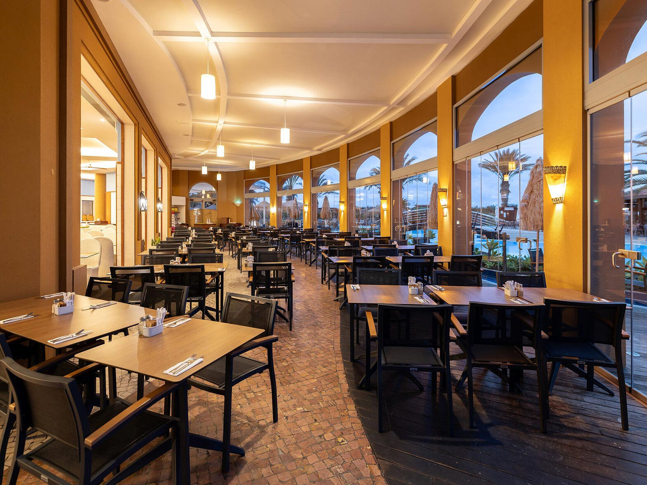 The Marés restaurant at the 5-star Resort in Porto Santo has an outdoor area with square tables and chairs.