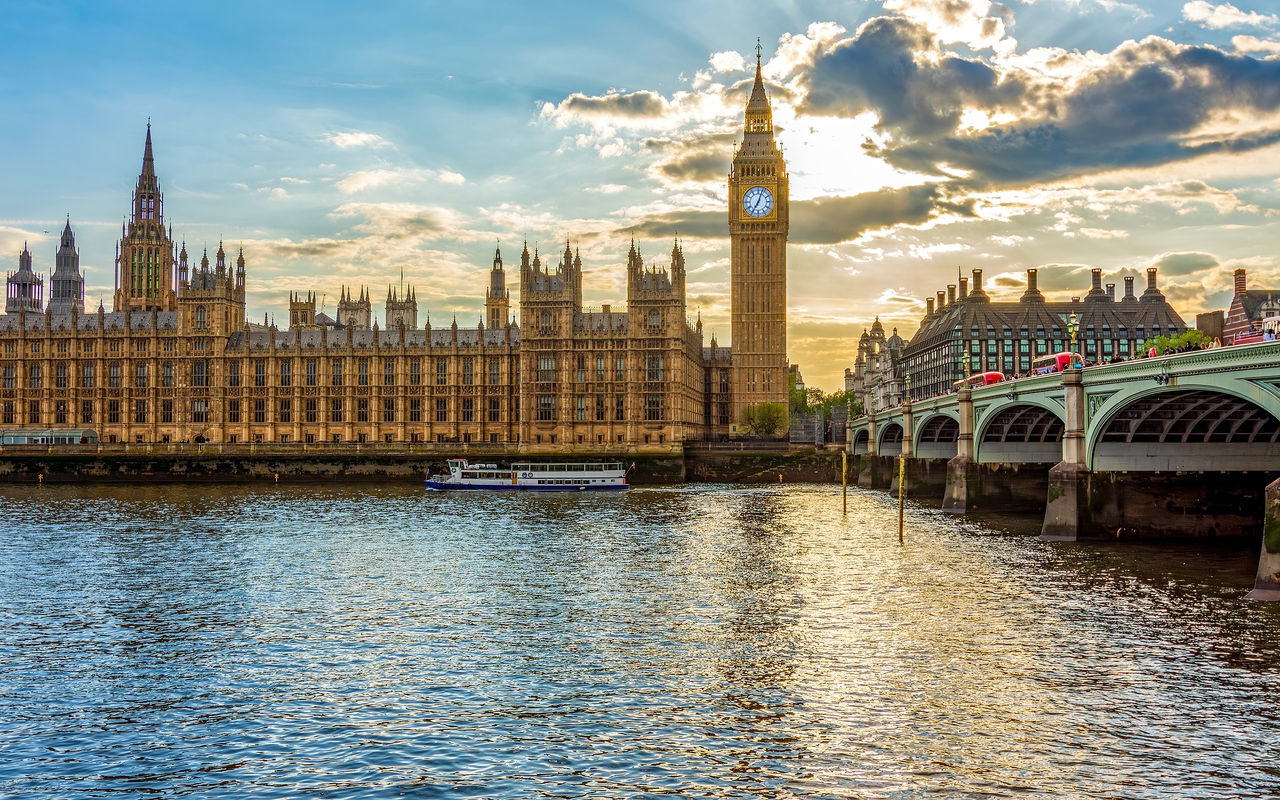 Panoramic view of the Palace of Westminster, in London, next to the iconic Big Ben, with the River Thames in the foreground