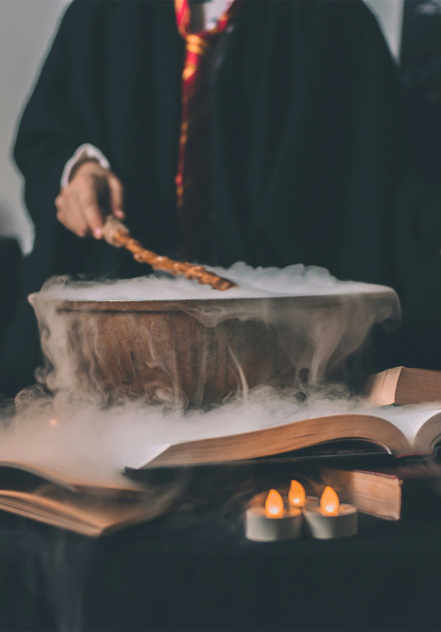 Harry Potter student brewing a magic potion with a wand smoke rising from the bowl and several candles around