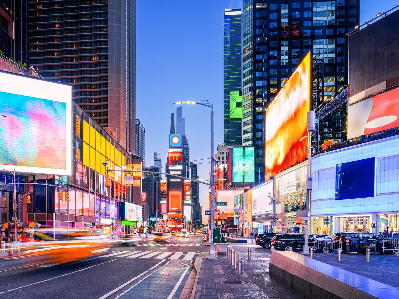 Famous Times Square in New York, seen from street level, filled with bright advertisements