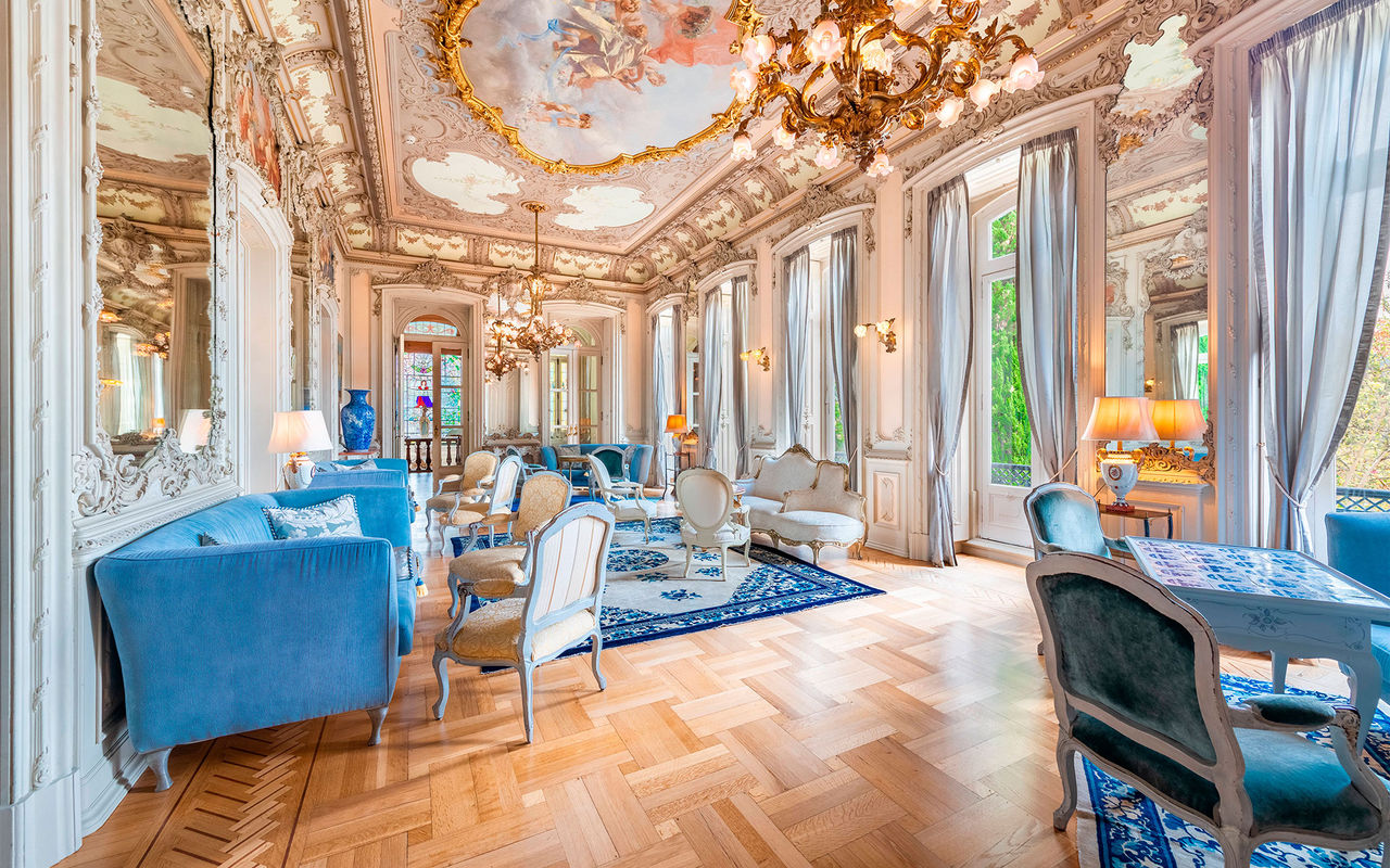 Room with historical decor and detailed ceiling in a luxury hotel in Portugal, belonging to the Pestana Collection brand